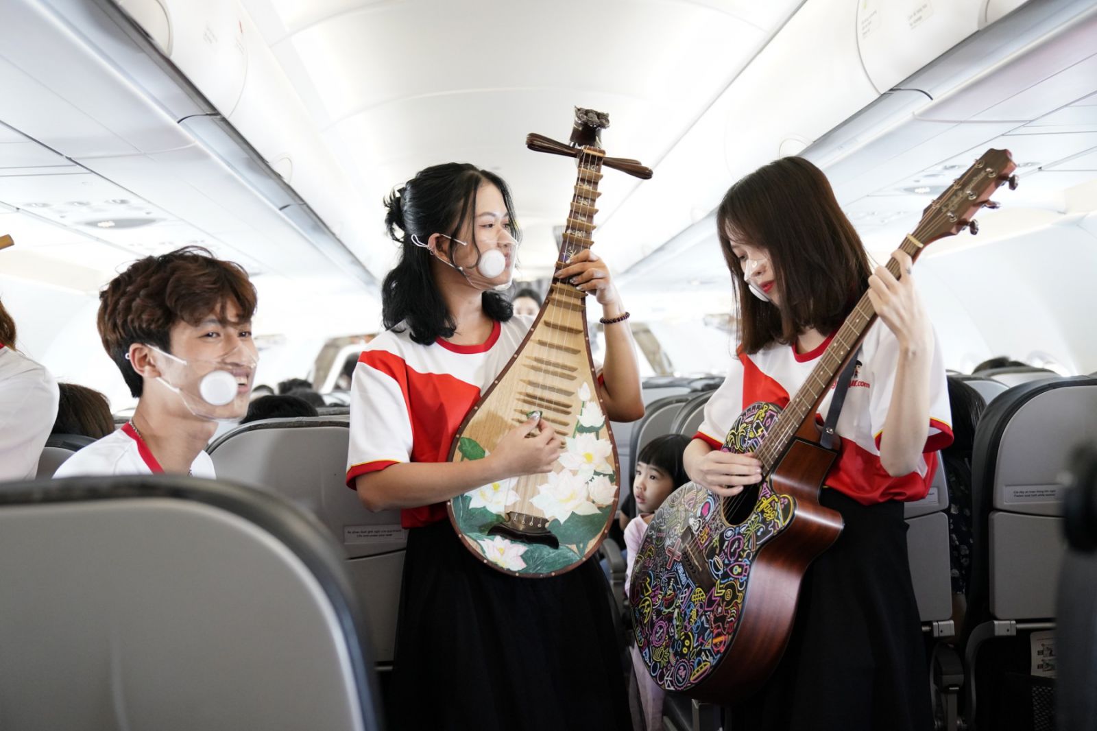 Trong trang phục mang màu cờ đỏ, sao vàng, các nghệ sĩ trẻ Vietjet đã dành tặng khách hàng các ca khúc trẻ trung ca ngợi thiên nhiên, đất nước, con người bằng các nhạc cụ truyền thống của dân tộc.
