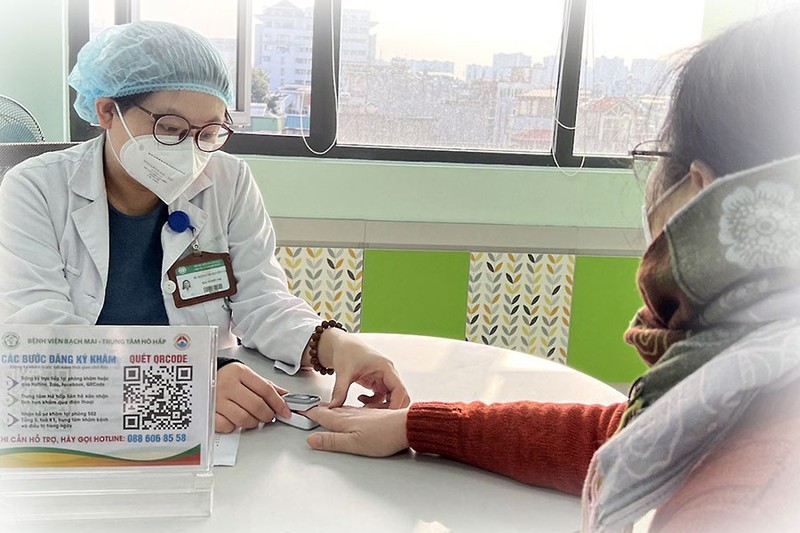 Bác sĩ Trung tâm hô hấp BV Bạch Mai (Hà Nội) kiểm tra độ bão hòa ôxy trong máu mao mạch cho bệnh nhân sau nhiễm COVID-19. Ảnh: NL