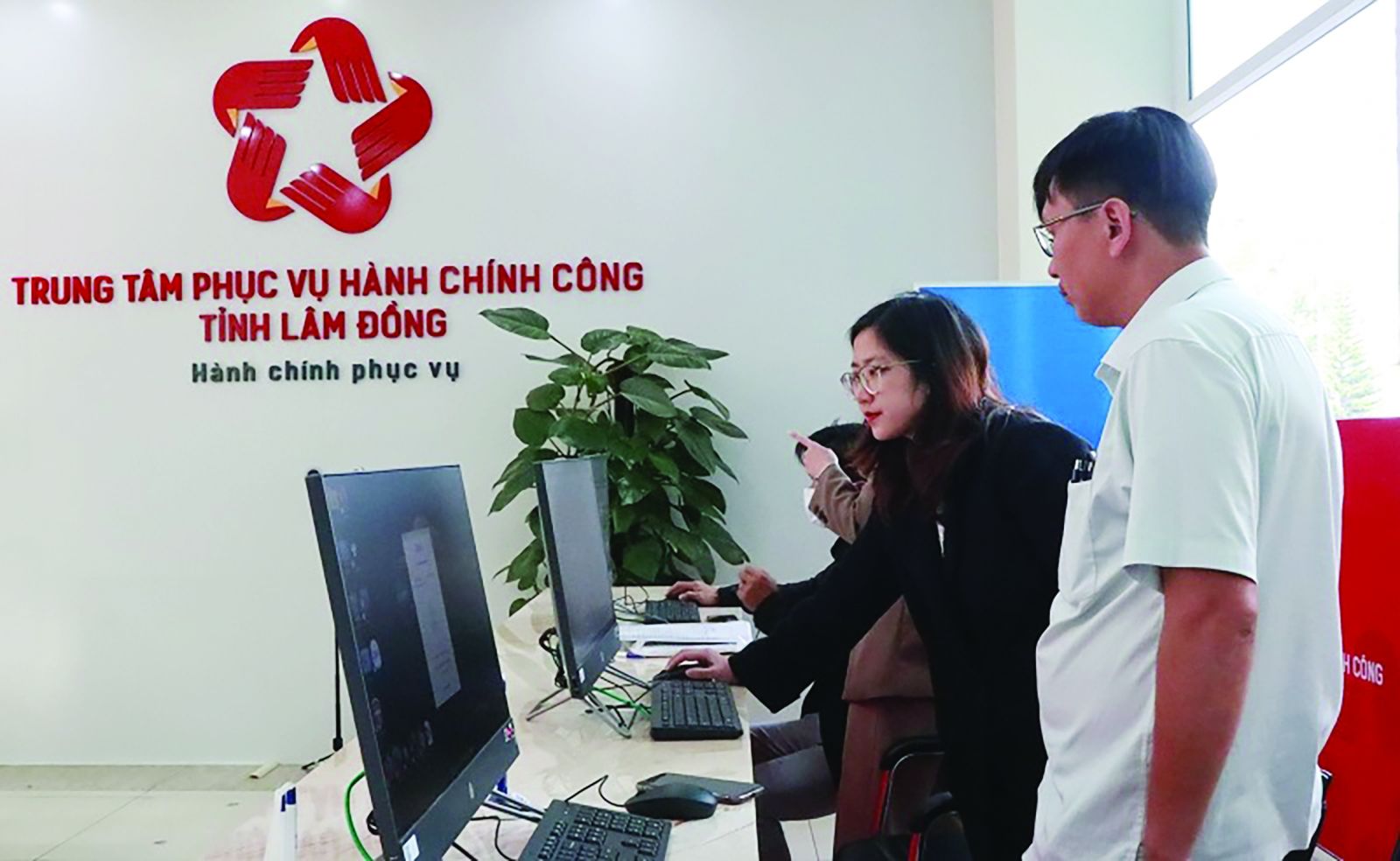  Cán bộ Trung tâm hành chính công tỉnh Lâm Đồng hướng dẫn người dân, doanh nghiệp nhập hồ sơ qua mạng.