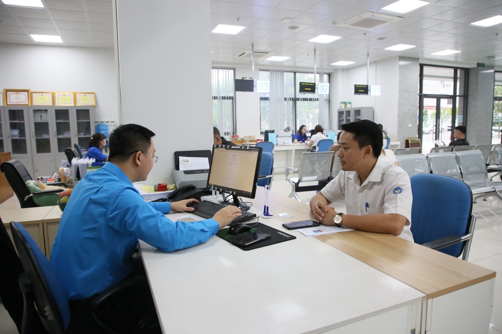 Công chức Trung tâm Phục vụ Hành chính công tỉnhQuảng Ninh hướng dẫn người dân thực hiện dịch vụ công mức độ 4 đổi GPLX trên Cổng dịch vụ công Quốc gia (Ảnh: Đỗ Phương)