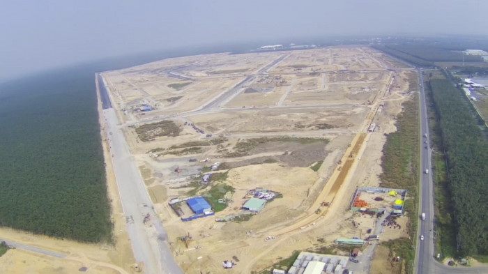 Một đoạn đường ĐT 769 hiện hữu (bên phải) đi qua khu tái định cư Lộc An - Bình Sơn đang xây dựng.