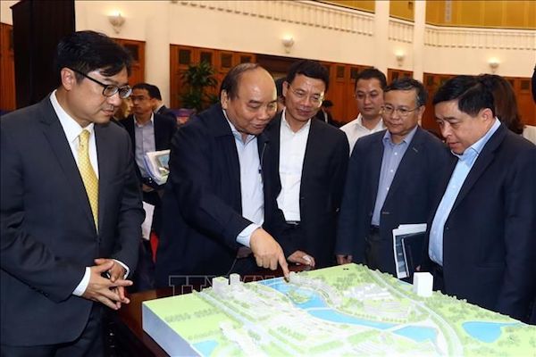 Thủ tướng Nguyễn Xuân Phúc, Bộ trưởng Bộ Kế hoạch và Đầu tư Nguyễn Chí Dũng và các đại biểu xem mô hình Trung tâm đổi mới sáng tạo quốc gia. (Nguồn: TTXVN)