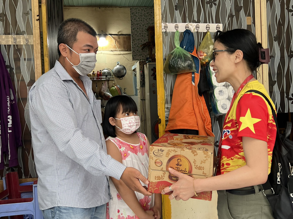 Chị Nguyễn Thị Hương Giang, đại diện Tập đoàn Tân Hiệp Phát, trao quà cho gia đình trẻ T.H.A ở Q.Gò Vấp
