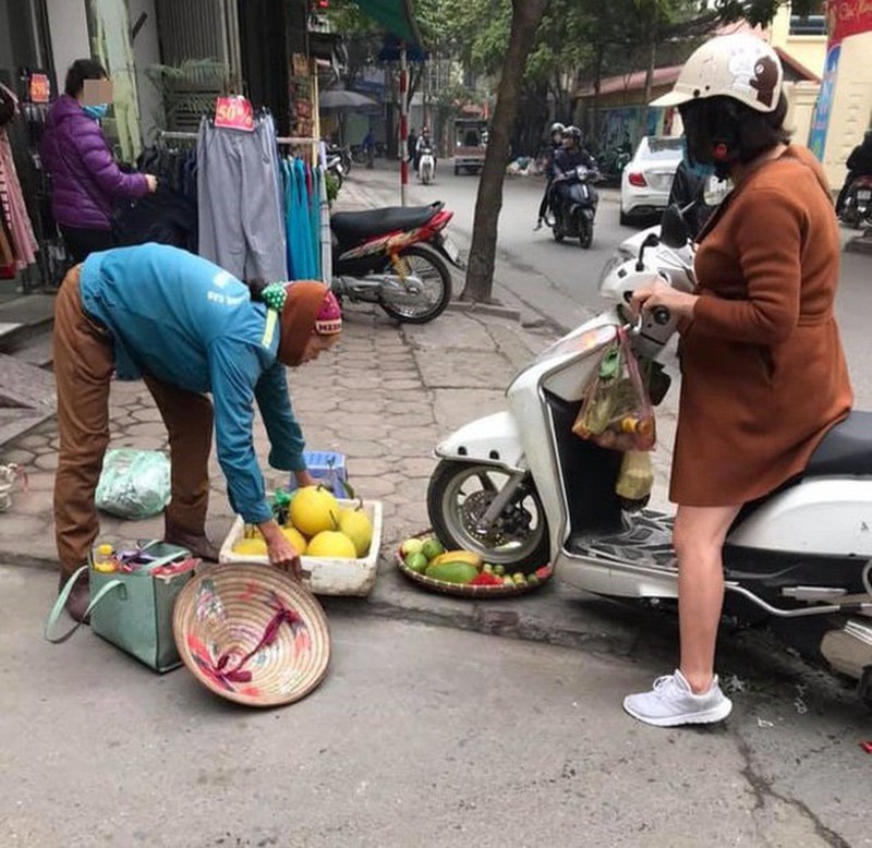 Hình ảnh người phụ nữ chèn lên mẹt hoa quả của người bán hàng rong (hình ảnh chia sẻ trên mạng xã hội).
