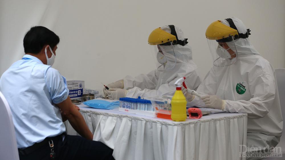 Nhân viên y tế lấy lấy mẫu xét nghiệm nhanh cho người về từ Đà Nẵng