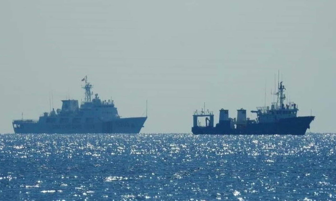 Tàu hải cảnh Trung Quốc (trái) đi gần một tàu không rõ quốc tịch trên Biển Đông ngày 14/4. Ảnh: Reuters