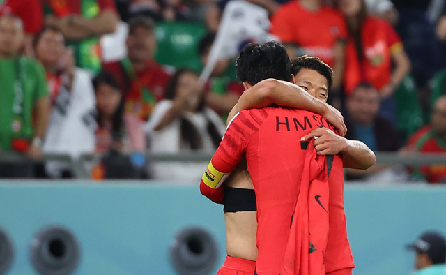 Son Heung-min ăn mừng với Hwang Hee-chan sau khi Hwang ghi bàn thắng thứ hai cho đội Hàn Quốc trong trận đấu bóng đá bảng H World Cup 2022 giữa Hàn Quốc và Bồ Đào Nha. (Ảnh: Yonhap)