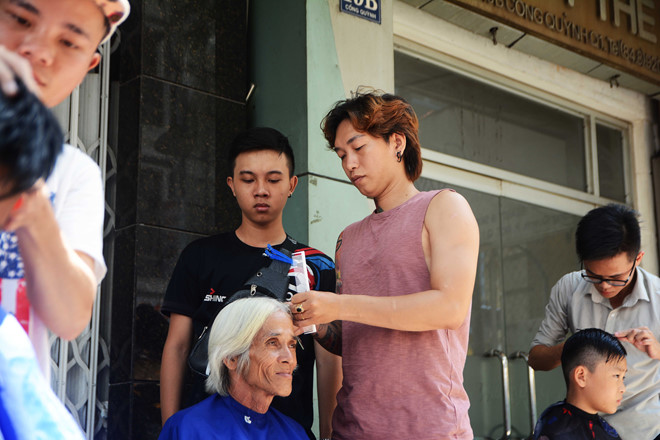 Lê Văn Khải (bên trái) đang hướng dẫn một bạn kỹ thuật cắt tóc.