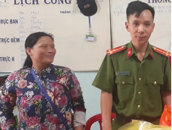 Chị Lê Thị Mai (bên trái) cùng cơ quan chức năng bàn giao số tiền nhặt được cho người đánh mất. 