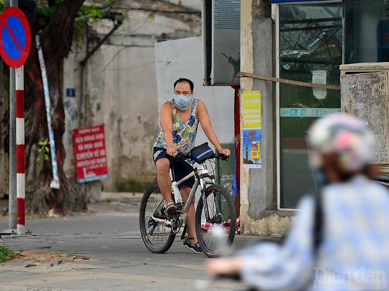 Một người dân đang đứng nghe ngóng chuẩn bị đạp xe ra đường trên phố Nguyễn Chí Thanh.