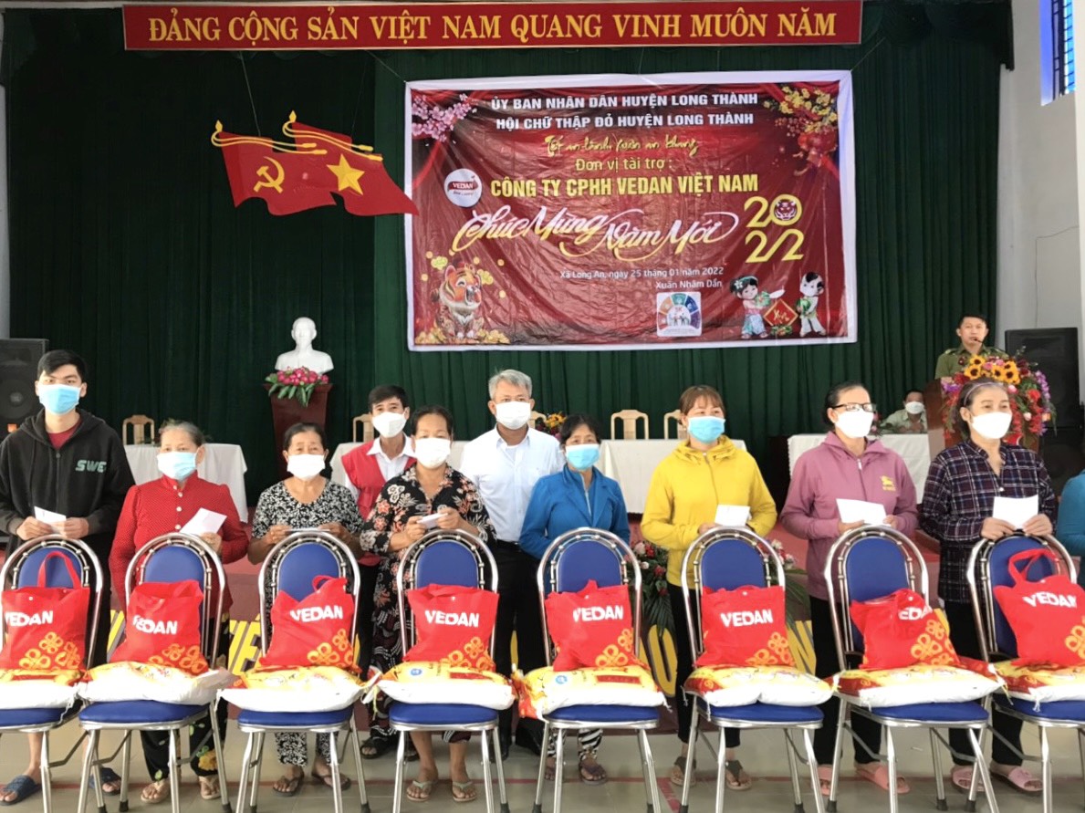 Đại diện Vedan Việt Nam (áo trắng giữa) trao quà Tết cho bà con tại địa phương xã Long An