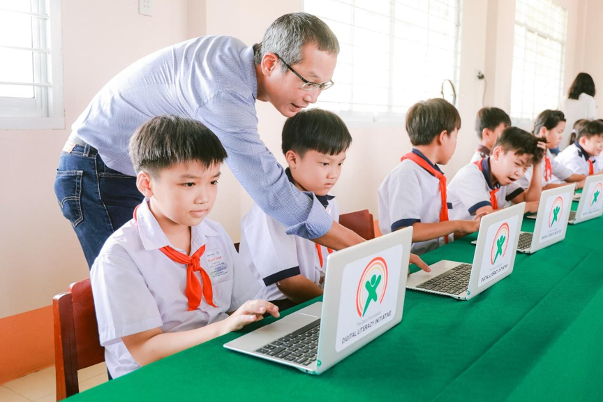 Các em học sinh được đại diện Qualcomm hướng dẫn cách sử dụng máy tính xách tay ACPC
