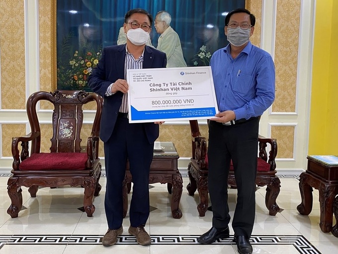 Ông Oh Tae Joon - Phó tổng giám đốc Shinhan Finance (trái) trao biểu trưng số tiền đóng góp 800 triệu đồng cho ông Trần Hữu Phước, đại diện Ủy ban Mặt trận Tổ quốc Việt Nam TP HCM ngày 31/3.