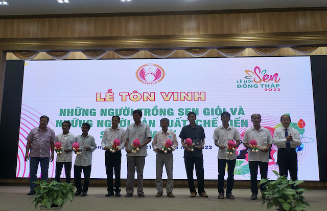 Phó Chủ tịch UBND tỉnh Đồng Tháp Đoàn Tấn Bửu (bìa phải) trao quà lưu niệm biểu dương nông dân trồng sen giỏi