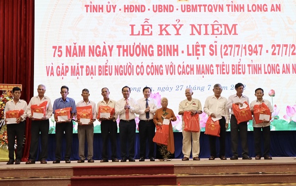 Bí thư Tỉnh ủy - Nguyễn Văn Được (thứ 6 từ trái sang), Chủ tịch UBND tỉnh - Nguyễn Văn Út (thứ 6 từ phải sang) tặng quà cho đại biểu người có công tiêu biểu trong ngày họp mặt