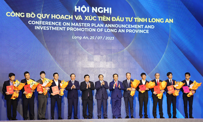 Thủ tướng Chính phủ - Phạm Minh Chính và lãnh đạo tỉnh chúc mừng các doanh nghiệp được trao chủ trương và giấy chứng nhận đầu tư tại hội nghị