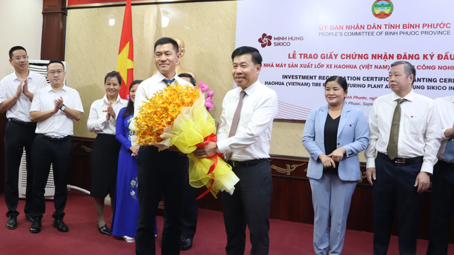 Bí thư Tỉnh ủy Bình Phước Nguyễn Mạnh Cường (thứ 5 từ phải qua) và lãnh đạo tỉnh Bình Phước tặng hoa chúc mừng nhà đầu tư.