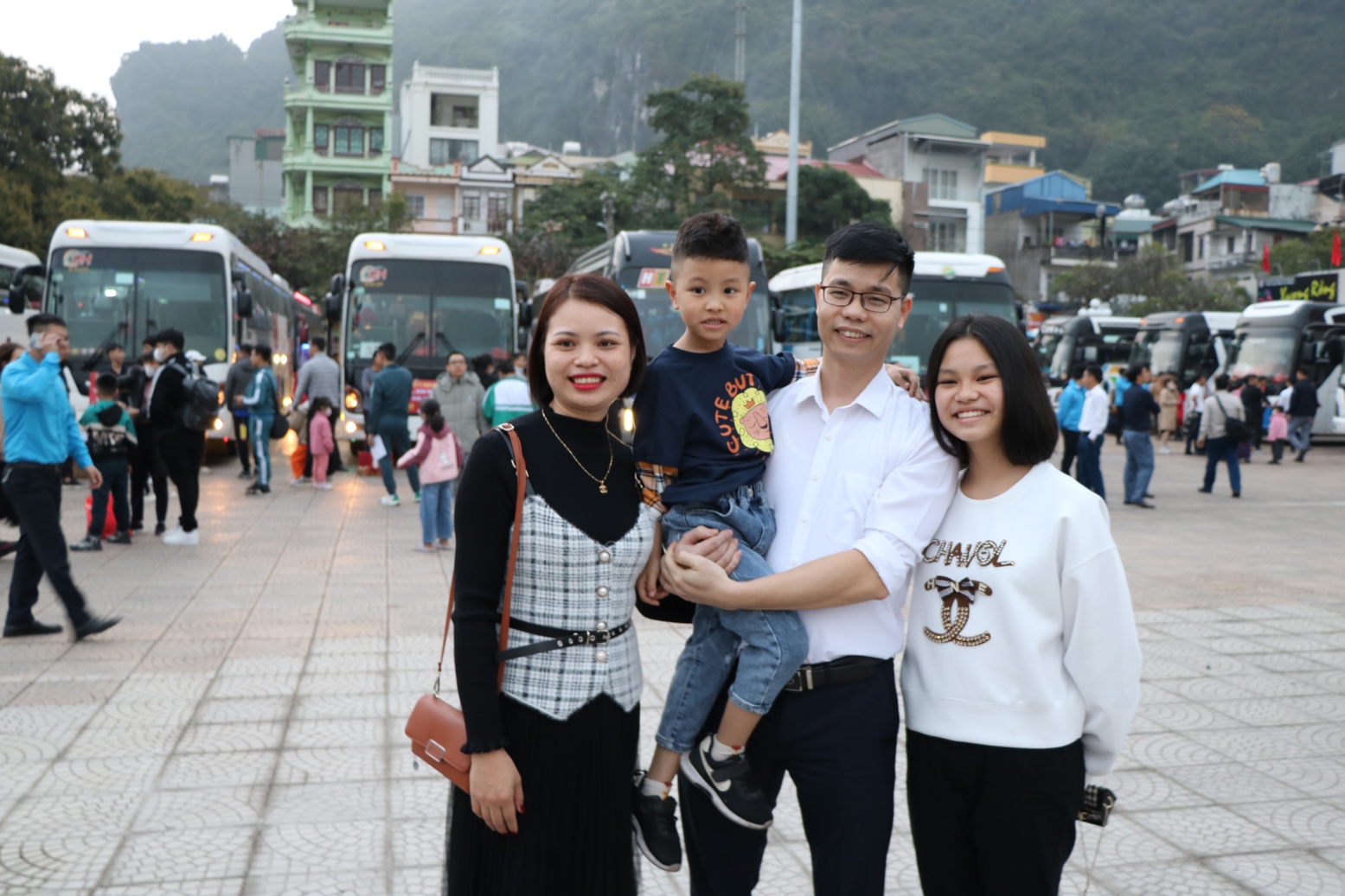 Gia đình thợ lò Phạm Ngọc Cảnh cùng vợ và hai con vui mừng, phấn khởi trước giờ lên xe về Đông Hưng, Thái Bình