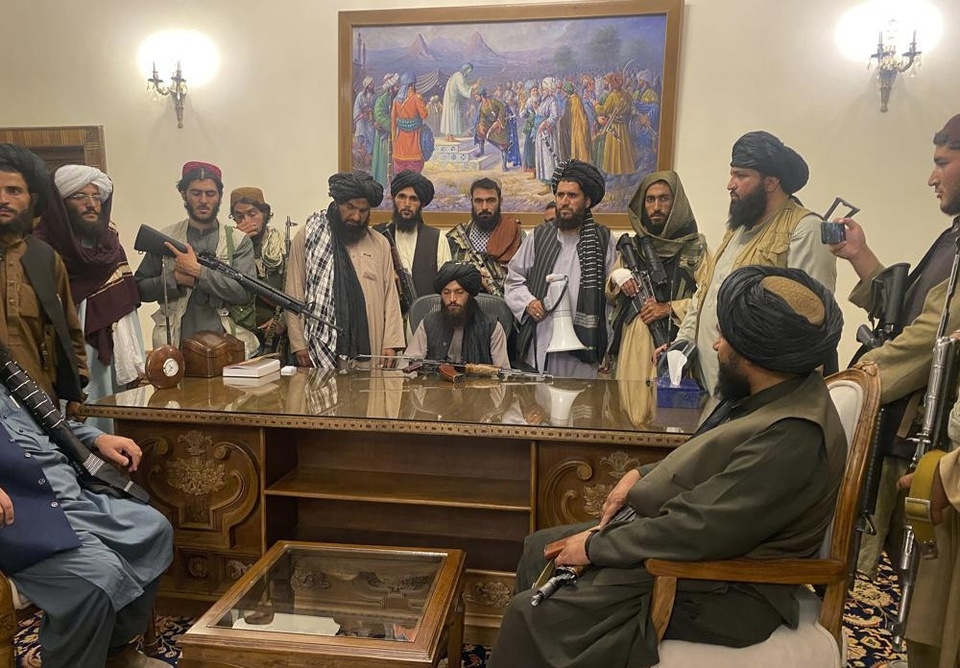 Các thủ lĩnh của Taliban bên bàn làm vệc của tổng thống ở Kabul. Ảnh: AP