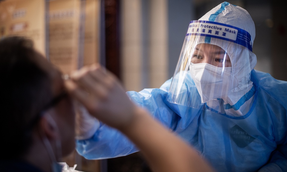 Một nhân viên y tế tại Vũ Hán đang lấy mẫu xét nghiệm cho người dân