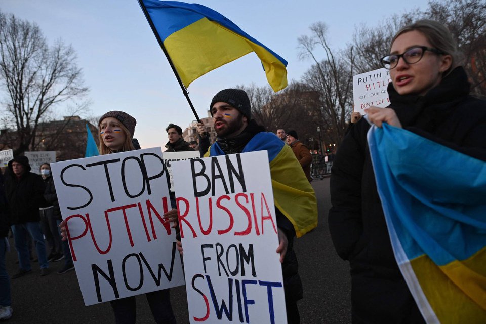 Người dân biểu tình giơ biểu ngữ đòi loại Nga khỏi SWIFT. Ảnh: AFP.