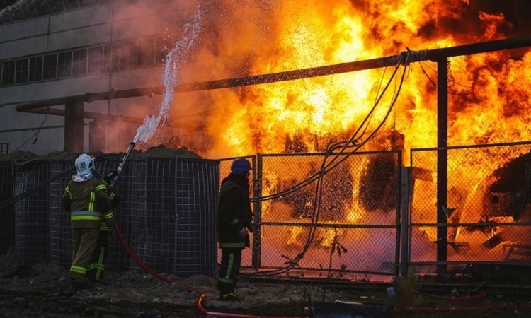 Lính cứu hỏa dập lửa tại một nhà máy nhiệt điện bị tấn công ở Kiev hôm 18/10. Ảnh: Reuters.