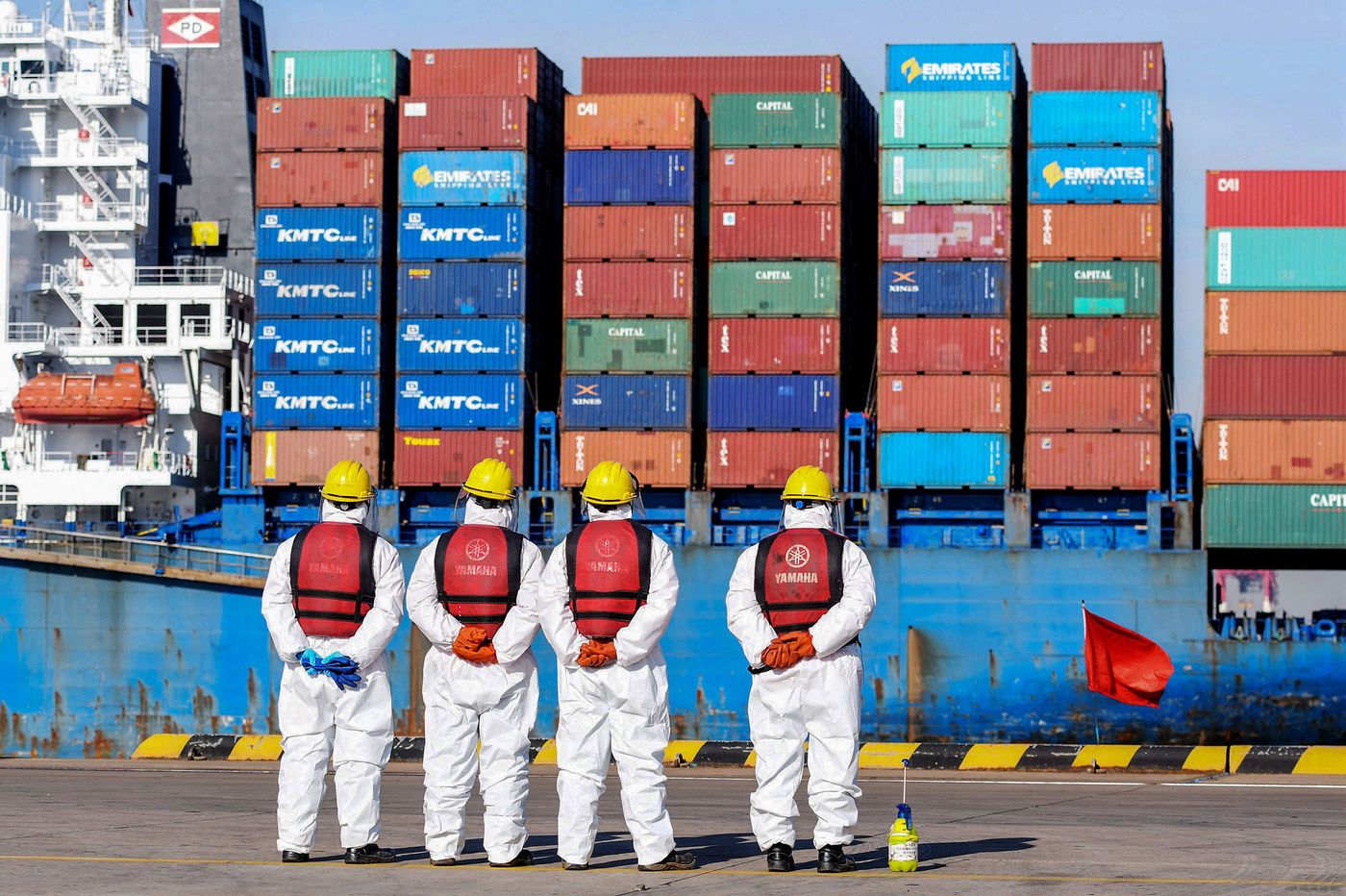 Các công nhân cảng biển trong trang phục bảo hộ ở Thanh Đảo, Trung Quốc tháng 1/2022 - Ảnh: Getty/Bloomberg.
