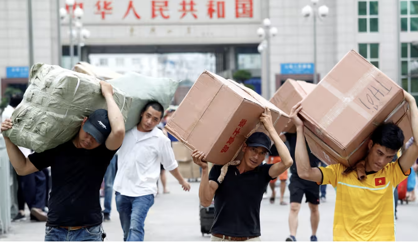  khuân vác hàng nhập khẩu vào Móng Cái từ Trung Quốc. Ảnh: Reuters