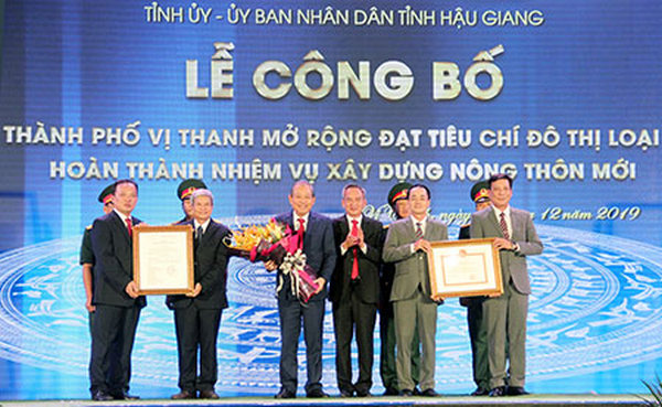 Phó Thủ tướng Thường trực Chính phủ Trương Hòa Bình (thứ 3 từ trái sang) trao bằng công nhận đô thị loại II và hoàn thành nhiệm vụ xây dựng NTM cho lãnh đạo TP. Vị Thanh.