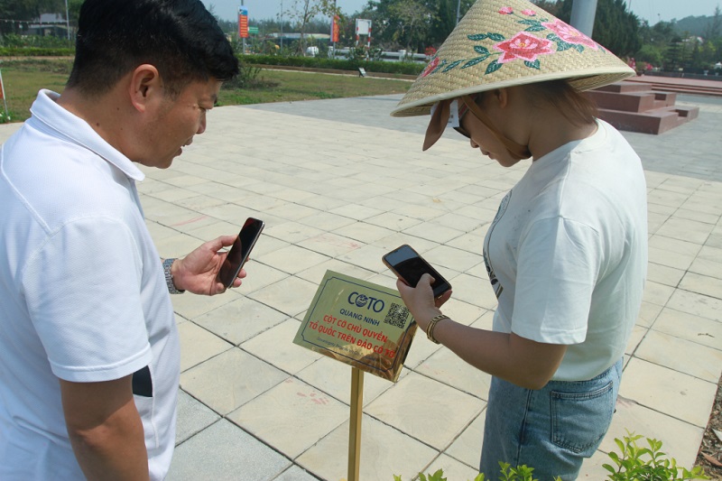 Du khách quét mã QR nghe thuyết minh tự động tại Di tích quốc gia đặc biệt khu lưu niệm Chủ tịch Hồ Chí Minh trên đảo Cô Tô (ảnh báo Quảng Ninh)