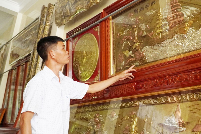 Nghệ nhân Nguyễn Hoàn bên những tác phẩm chạm đồng tinh xảo có giá trị cao (Ảnh: Báo Thái Bình)