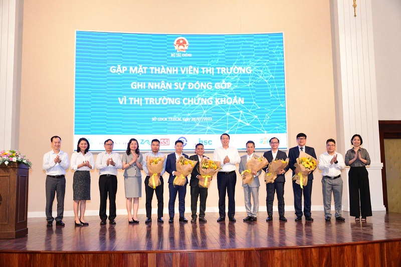 Thứ trưởng Nguyễn Đức Chi (thứ 6 từ trái sang) tặng hoa cảm ơn các thành viên thị trường ngày 28/7/2022 