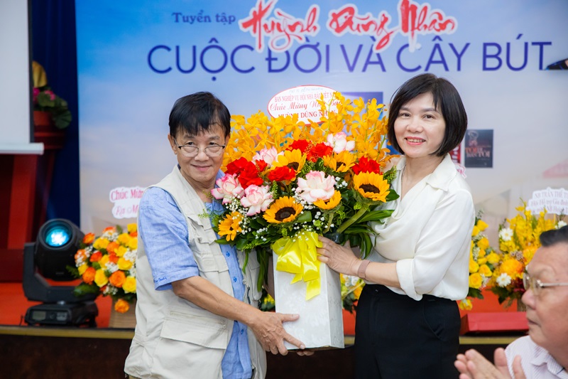 Bà Đỗ Thu Hằng, Trưởng Ban Nghiệp vụ Hội Nhà báo Việt Nam, tặng hoa chúc mừng nhà báo Huỳnh Dũng Nhân