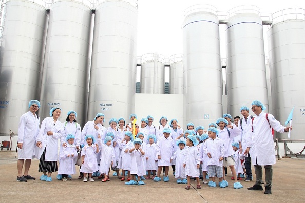 Các bé chụp ảnh cùng bố mẹ tại khu vực bồn chứa sữa tươi khổng lồ của nhà máy.