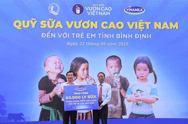 Ông Đỗ Thanh Tuấn - Giám đốc Đối ngoại Vinamilk trao biển tượng trưng tặng 64.000 ly sữa cho ông Nguyễn Mỹ Quang – Giám đốc Sở Lao động, Thương binh và Xã hội tỉnh Bình Định.