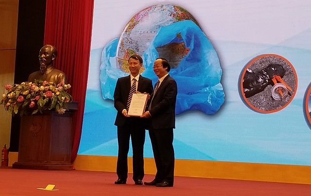 Ông Phạm Duy Hưng- Giám đốc Pháp lý và Đối ngoại FrieslandCampina VN (trái) trao cam kết chống rác thải nhựa cho ông Võ Tuấn Nhân- Thứ trưởng Bộ TN&MT