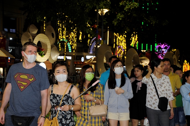 Lo ngại dịch bệnh viêm phổi do virus corona, người dân TP. HCM đeo khẩu trang thưởng lãm đường hoa Nguyễn Huệ
