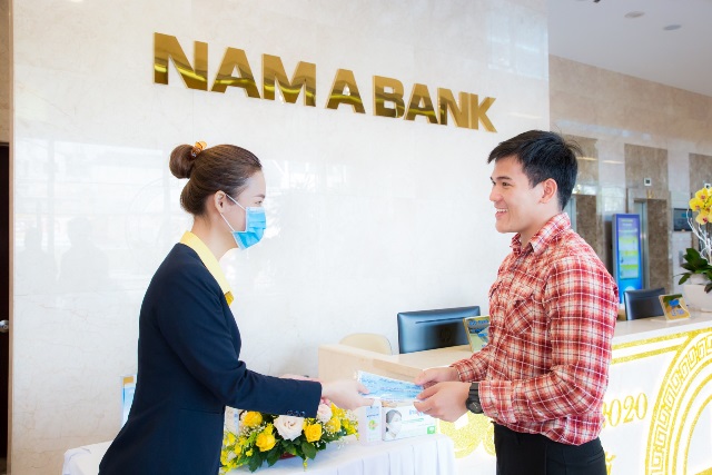 Cán bộ của Nam A Bank phát khẩu trang cho khách hàng đến giao dịch