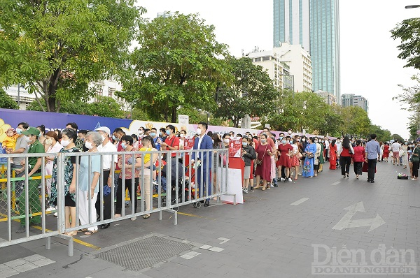 Người dân và du khách xếp hàng vào tham quan đường hoa Nguyễn Huệ.