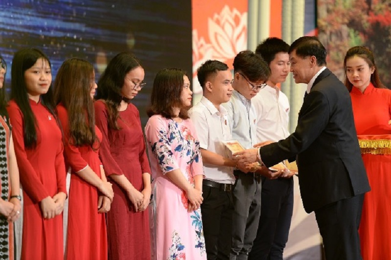 Doanh nhân Johnathan Hạnh Nguyễn, đại diện Quỹ học bổng Vừ A Dính trao học bổng cho các em học sinh.