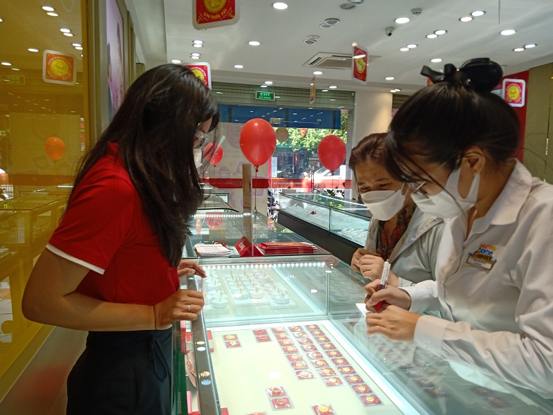 Nhân viên cửa hàng DOJI Trường Chinh tư vấn cho khách hàng lựa chọn sản phẩm.