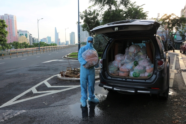Đại đức Thích Pháp Tịnh bên chiếc xe hàng ngày vận chuyển thực phẩm hỗ trợ tặng cho bà con khó khăn vùng dịch