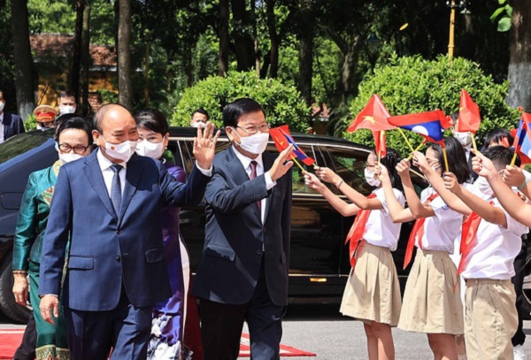 Chủ tịch nước Nguyễn Xuân Phúc (trái) và Tổng Bí thư, Chủ tịch nước Lào Thongloun Sisoulith với thiếu nhi Thủ đô Hà Nội tại lễ đón sáng 28-6 - Ảnh: TTXVN