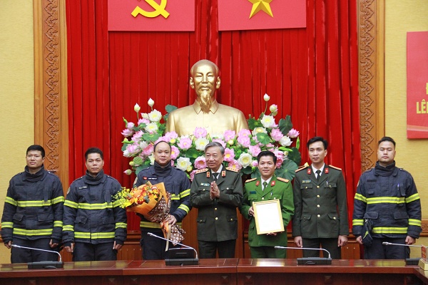 Bộ trưởng Bộ Công an - Đại tướng Tô Lâm trao quyết định cho các thành viên trong đoàn cứu nạn, cứu hộ. Ảnh: Trọng Phú