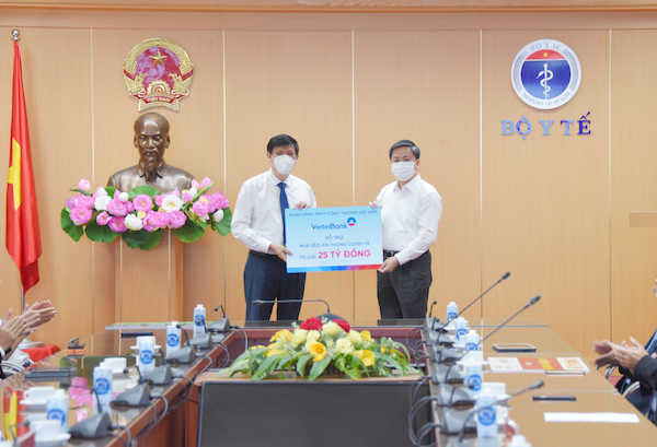 Ông Lê Đức Thọ - Ủy viên Trung ương Đảng, Bí thư Đảng ủy, Chủ tịch HĐQT VietinBank (bên phải) trao tặng 25 tỷ đồng hỗ trợ mua vắc-xin phòng COVID-19