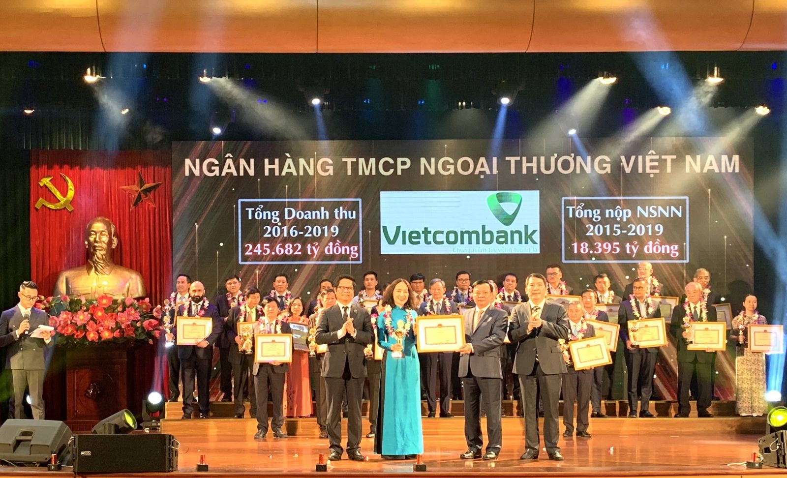 Bộ trưởng Bộ Tài chính Đinh Tiến Dũng trao tặng Bằng khen cho bà Nguyễn Thị Kim Oanh – Phó Tổng Giám đốc Vietcombank, đại diện Vietcombank lên sân khấu nhận vinh danh (Ảnh – Huy Thắng)