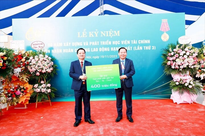 Ông Lại Hữu Phước - Trưởng Ban kiểm soát Vietcombank thay mặt cho các cựu học viên Học viện tài chính tại Vietcombank (bên phải) đóng góp 400 triệu đồng cho Quỹ Tâm - Tài - Chính
