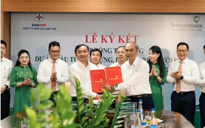 Ông Trương Sỹ Nghị - Phó Giám đốc phụ trách điều hành Vietcombank Kon Tum (bên trái) và ông Nguyễn Văn Hạnh - Giám đốc Công ty Điện lực Kon Tum (bên phải) thực hiện nghi thức ký kết