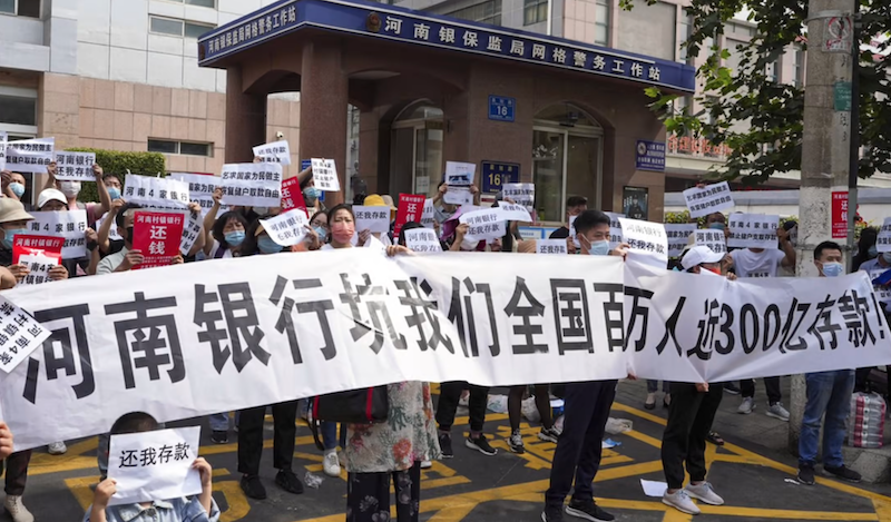 Nhiều người gửi tiết kiệm tại các ngân hàng tại hai địa phương trên không thể rút khoản tiết kiệm của mình, đồng thời xuống đường biểu tình để đòi quyền lợi (ảnh: Weibo)