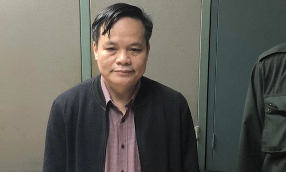 Cơ quan điều tra tống đạt lệnh bắt tạm giam giám đốc CDC Bắc Giang Lâm Văn Tuấn - Ảnh: GIANG LONG/TUỔI TRẺ.